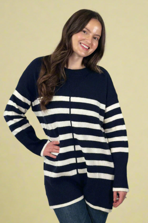 Model is wearing a long length crew neck sweater with navy and white stripes.
