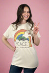 Model is wearing a cream colored vintage tee with a colorful peace graphic with a dove and a rainbow. 