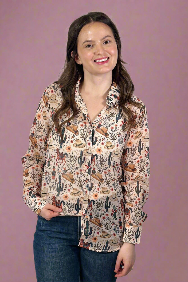 Model is wearing a sheer lightweight button up top featuring a funky western inspired print. 
