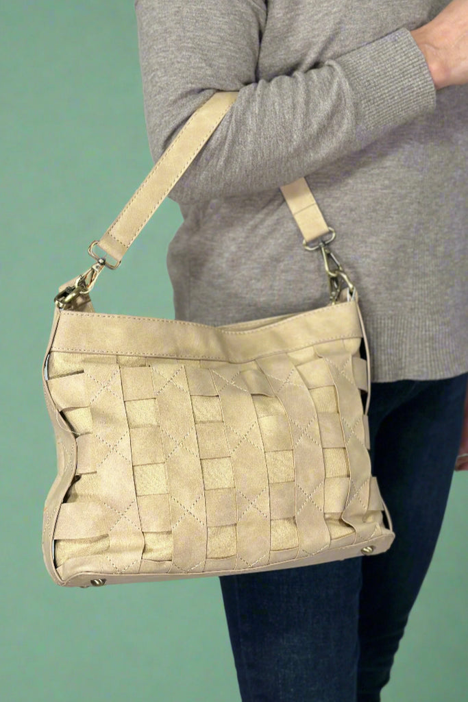 Women’s shoulder bag in beige with “caged” woven strap layer over faux suede base. Comes with removable shoulder and adjustable crossbody strap.