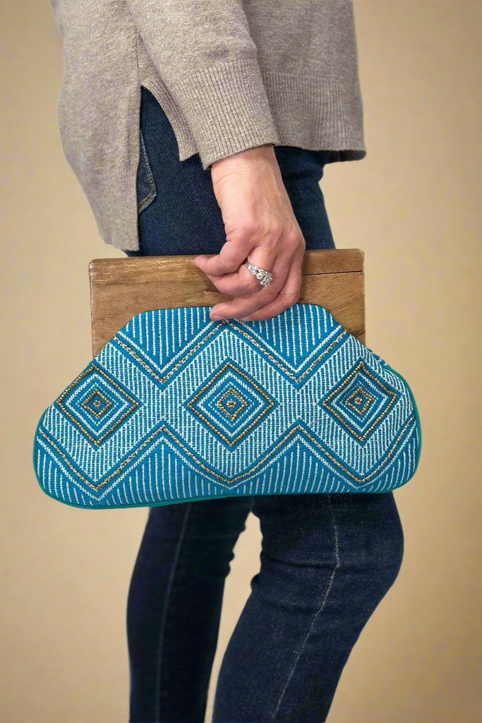 Wood handled clutch in blue with white embroidery and gold beaded accent.