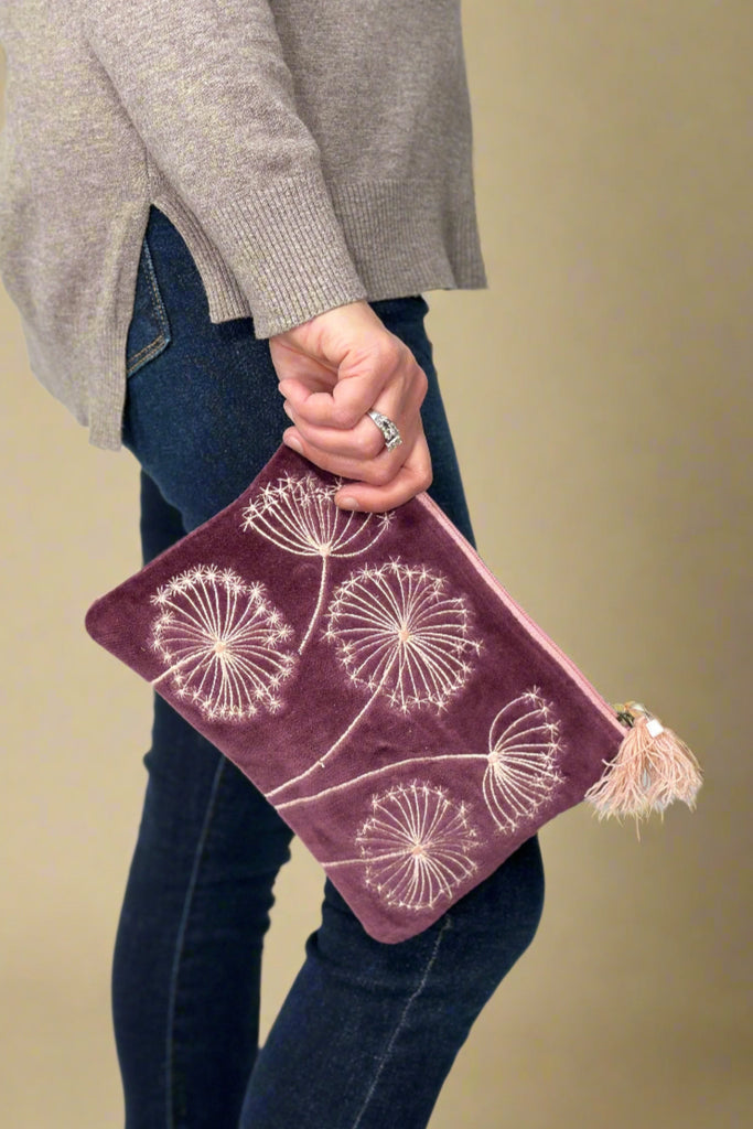 Purple velvet clutch or makeup bag with light pink embroidered queen Anne’s lace and tassel zipper details.