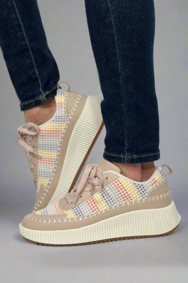 A pair of women’s platform sneakers with red, blue, and yellow striped pattern and beige accents with whipstitch detail.