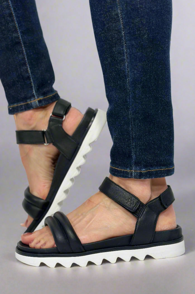 Women’s leather sandals in black and white sole with over the toe strap and Velcro ankle strap.