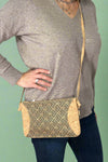Model is wearing a cork crossbody with a pattern detail. 