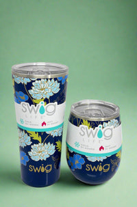 An image of a Swig mugs featuring a water lily pattern on a dark blue background. It is insulated, with a stainless steel body and a spill-resistant lid.