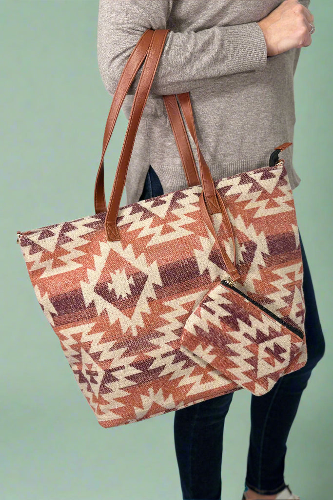 Model is holding a western printed tote bag with a removable clutch. 