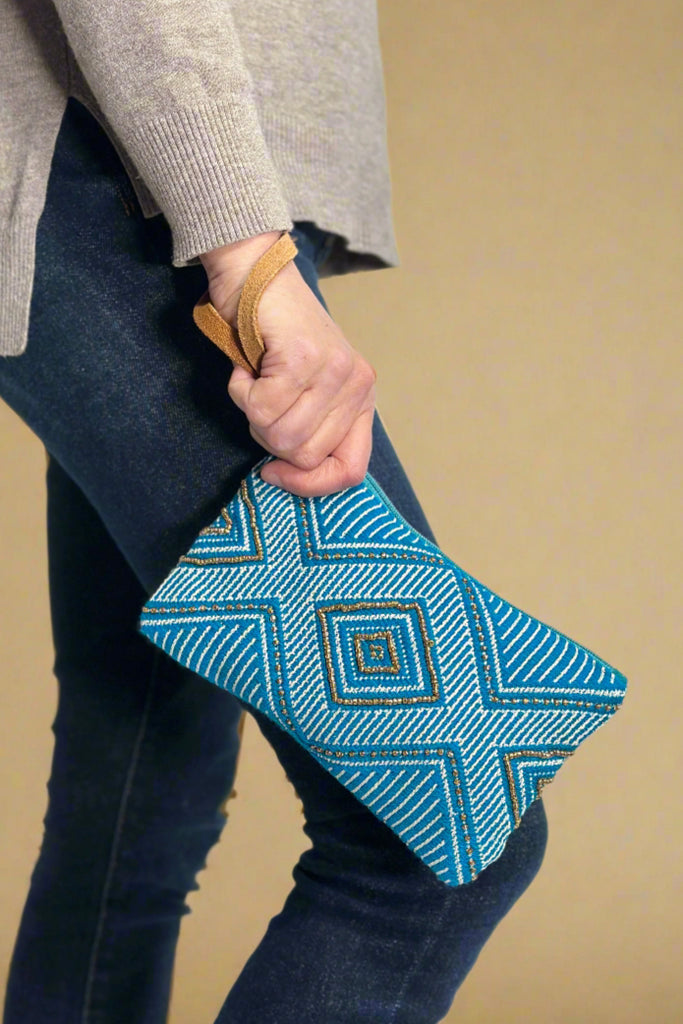 Model is holding an embroidered beaded wristlet.