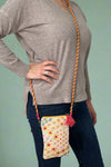 Model is wearing a small colorful crossbody bag.