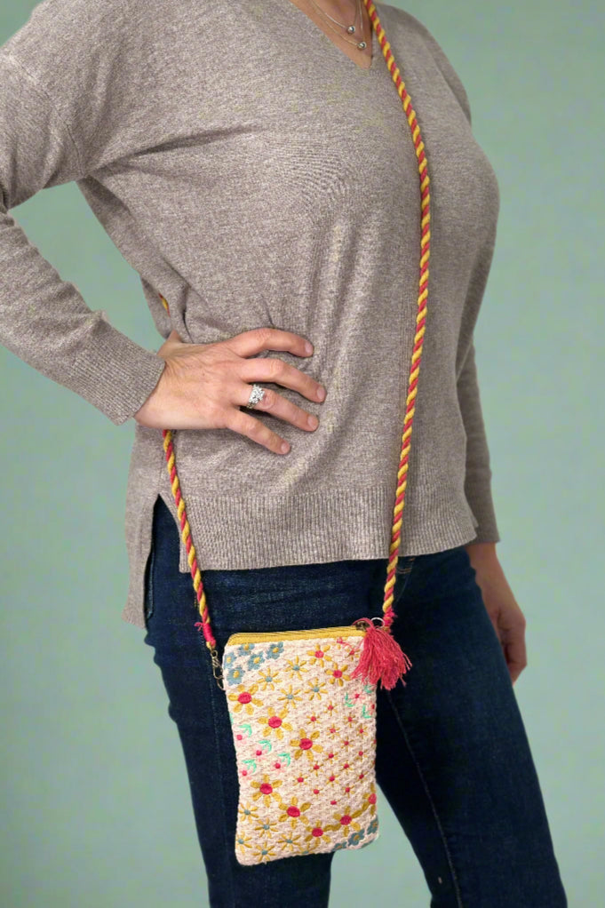 Model is wearing a small colorful crossbody bag.