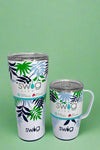An image of a Swig mugs featuring a blue and green tropical leaf pattern on a white  background. It is insulated, with a stainless steel body and a spill-resistant lid.