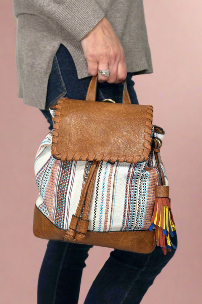 Model is wearing a boho style mini backpack purse. 