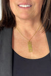 Short gold necklace featuring stacked mid century modern breeze blocks pendant.
