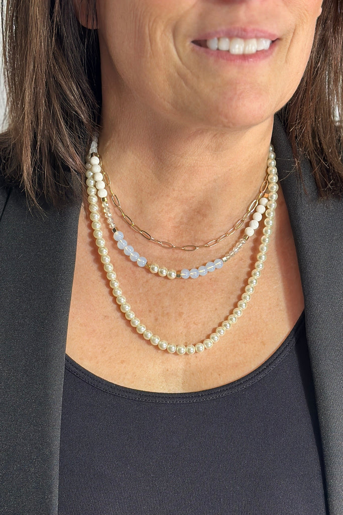 3 layered necklace with one chain link, one faux pearl, and one faux pearl and iridescent beaded layers.