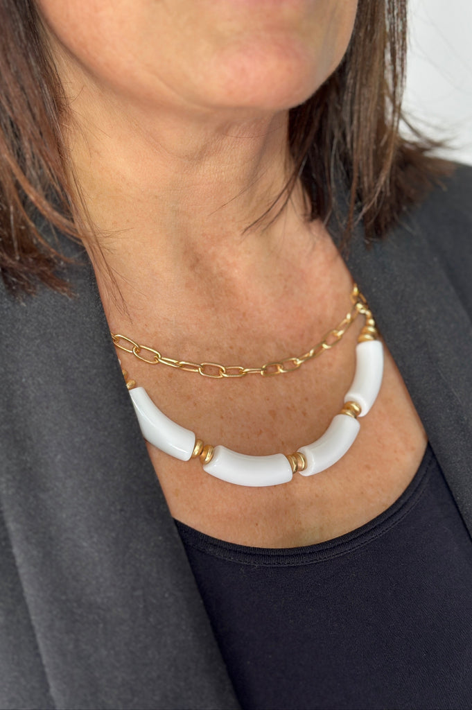 Short layered necklace with gold plated chain link and longer white beaded layer.