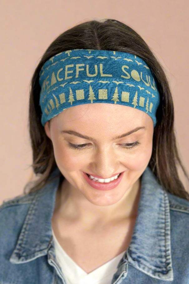 Model is wearing a heathered teal headband with the phrase "peaceful soul" printed across the front. 