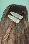 Model is wearing two sparkly hair clips.