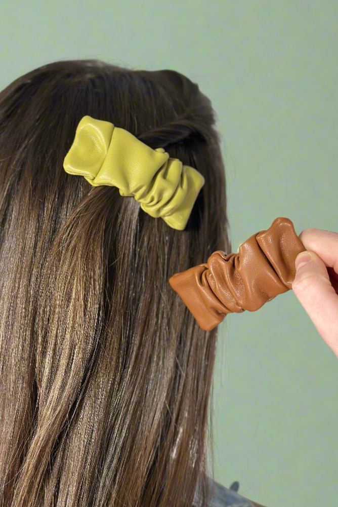 Model is showing off two faux leather hair clips.