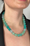 Model is wearing a collar length beaded necklace.