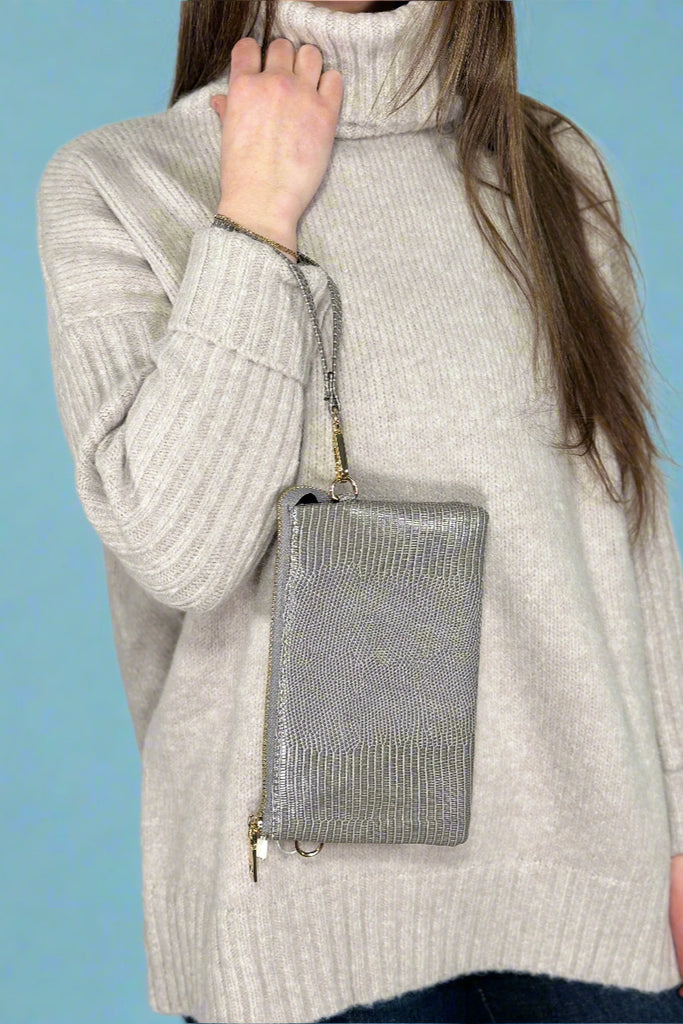 Small faux leather, 3 compartment bag in grey with zipper closure and removable wristlet and adjustable crossbody straps.