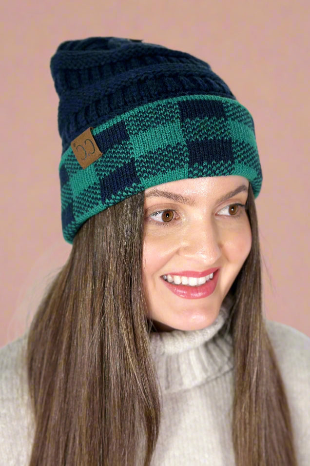 Model is wearing a beanie with a contrasting plaid cuff.