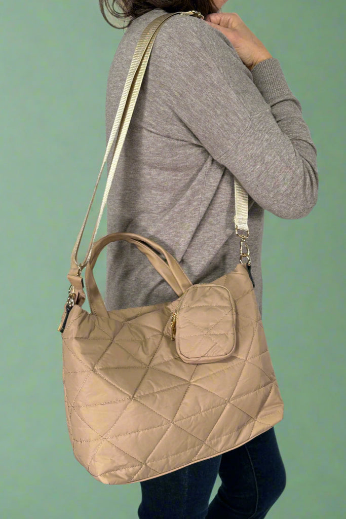 Lightweight quilted nylon hand bag in beige with detachable adjustable strap for crossbody or shoulder wear. Comes with matching coin pouch.