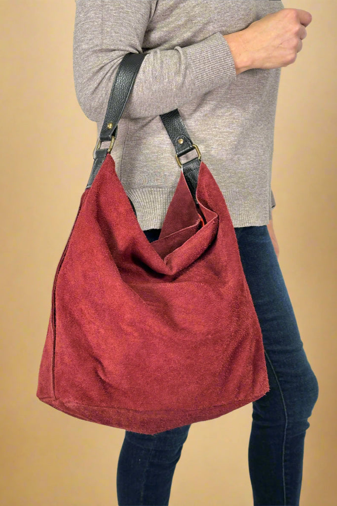 Women’s large Italian leather suede shoulder bag in burgundy with zipper closure.