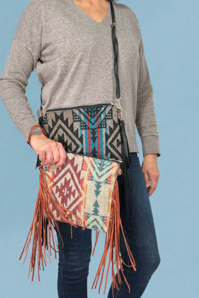 Model is showing off an aztec printed crossbody with fringe available in two colors. 