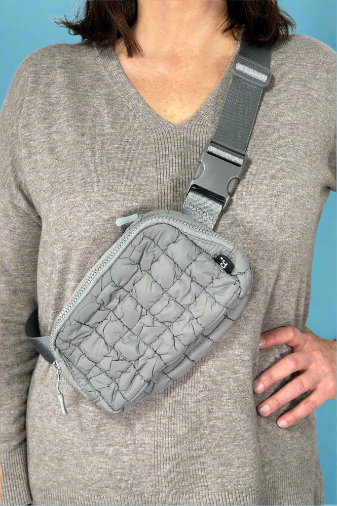 Model is wearing a grey quilted nylon fanny style bag.