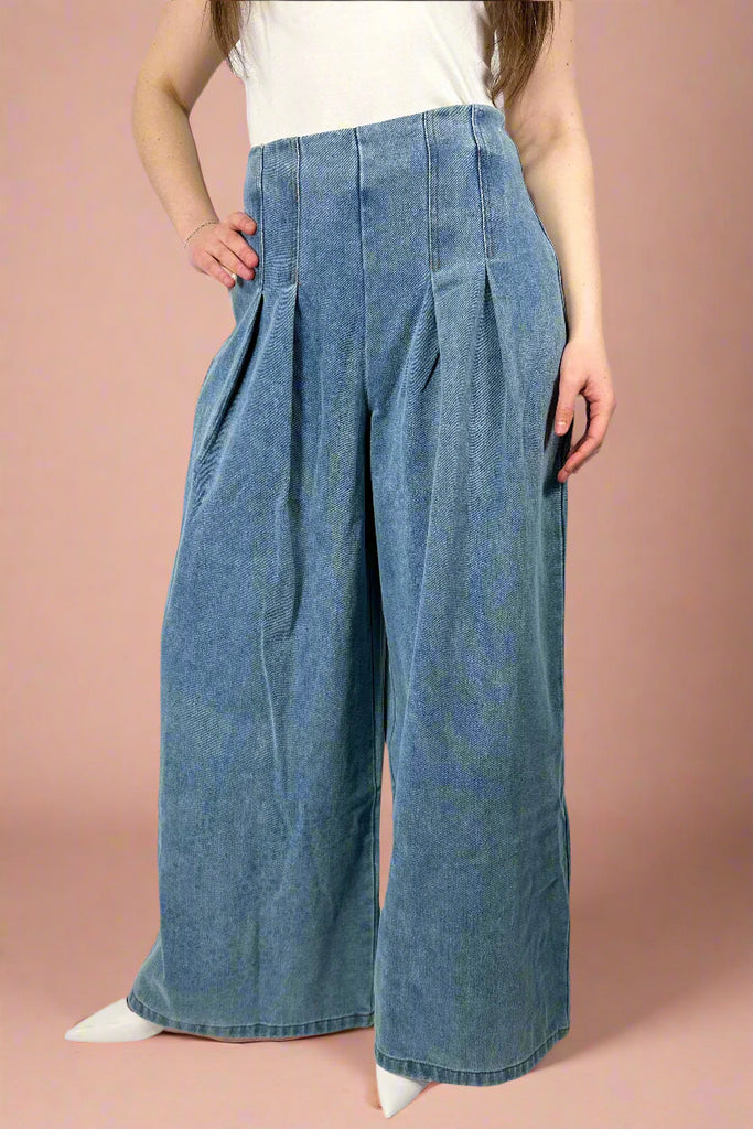 These high waisted denim features a pleated waist and wide legs. It has a hidden denim zipper on the back.