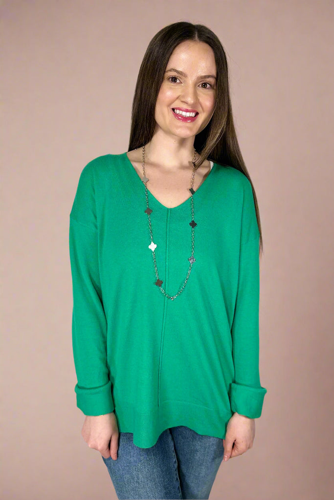 This stretchy, v-neck top is an apple green color. It has a soft texture, long sleeves, and long length.