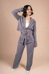 Model is wearing straight leg tie front trousers in grey with subtle pinstripes