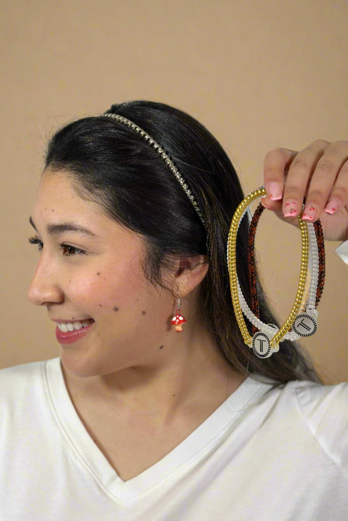 Model is wearing a rubber headband and holding up the same headband in three additional colors.