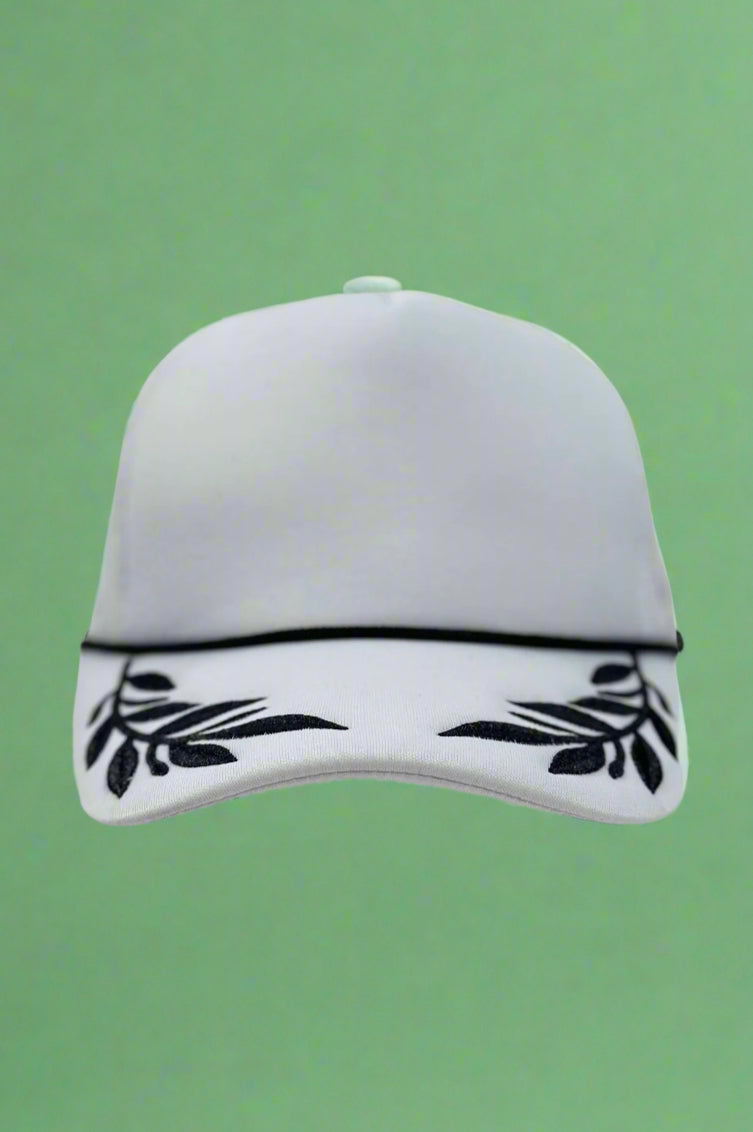 White foam trucker hat with black leaf pattern. Adjustable.
