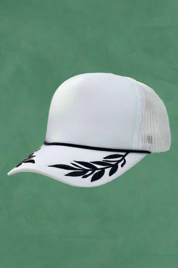 White foam trucker hat with black leaf pattern. Adjustable.