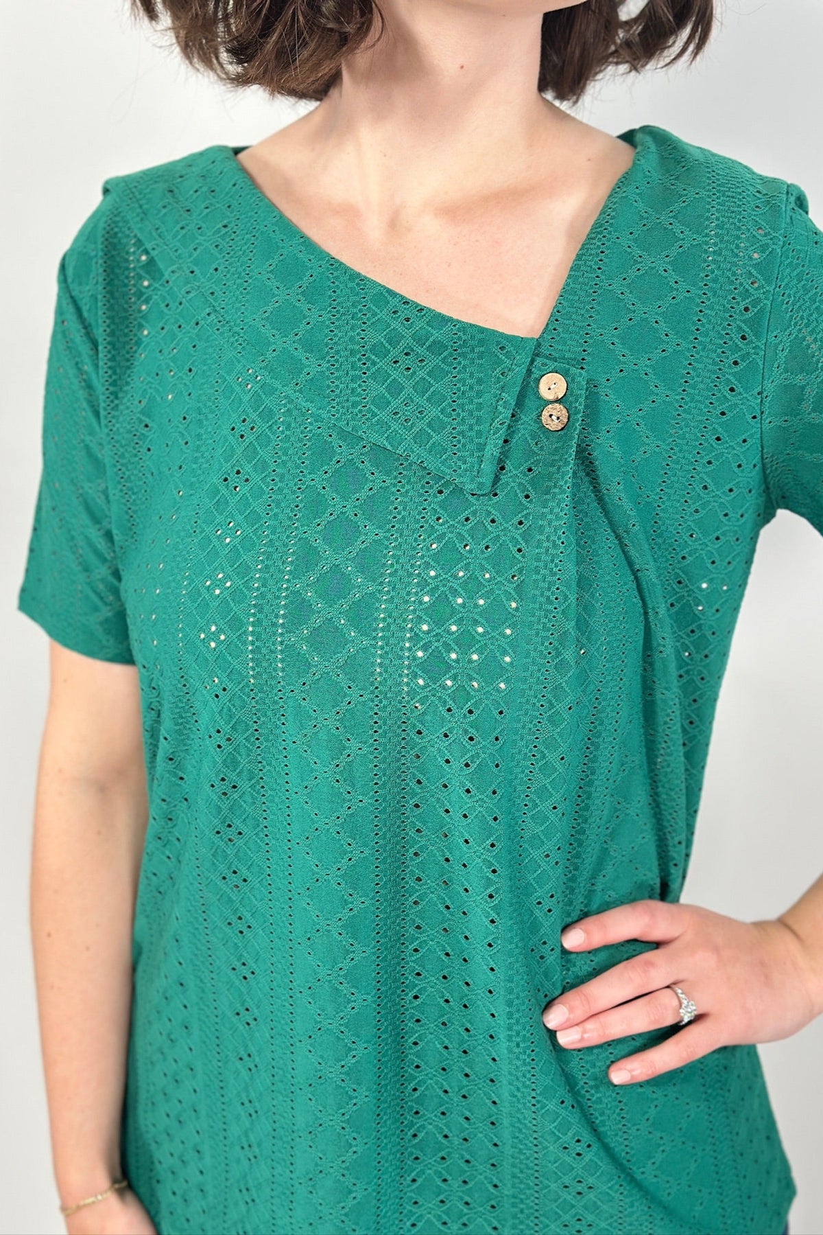 Green lace top worn by a person on a white background