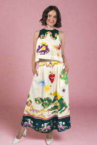 Woman wearing a colorful dress with various designs on a white background