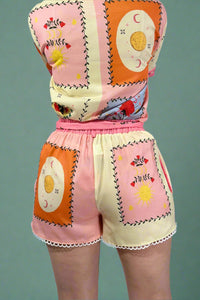 Colorful outfit with a patterned top and shorts on a gray background