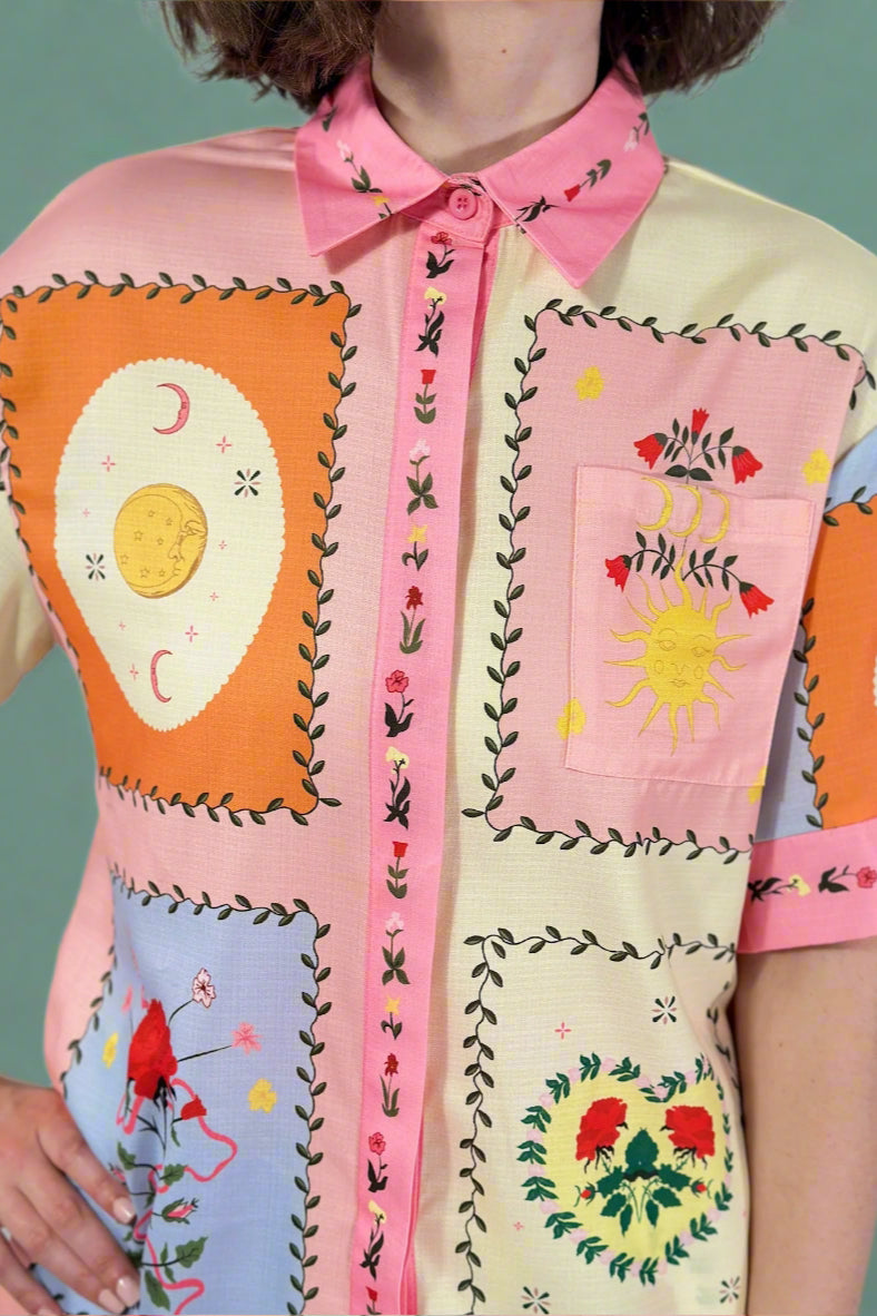 Colorful patchwork dress with embroidered patterns on a plain background