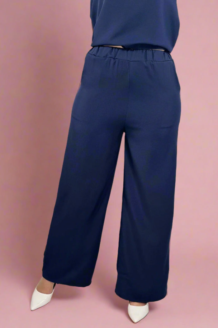Navy blue pants worn by a person on a white background