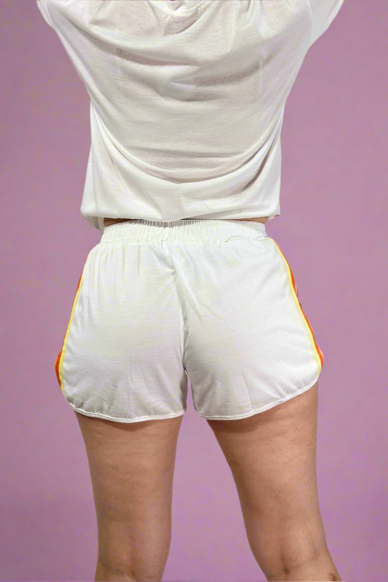 White athletic shorts with yellow accents on a plain background