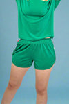 Green sports outfit with a shirt and shorts on a plain background