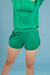 Green sports outfit with a shirt and shorts on a plain background