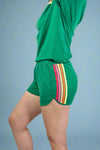 Green athletic outfit with colorful stripes on a plain background
