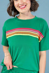 Person wearing a green t-shirt with colorful stripes on a plain background