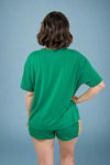 Person wearing a green outfit on a plain background