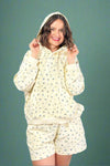 Woman wearing a matching floral hoodie and shorts set on a gray background