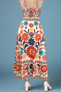 Woman wearing a short sleeve blue floral dress with elastic waist against a plain background