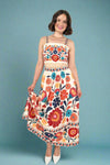 Woman wearing a colorful floral crop top and skirt set on a blue background