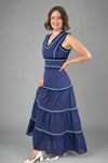 Woman wearing a blue dress with white embellishments on a white background